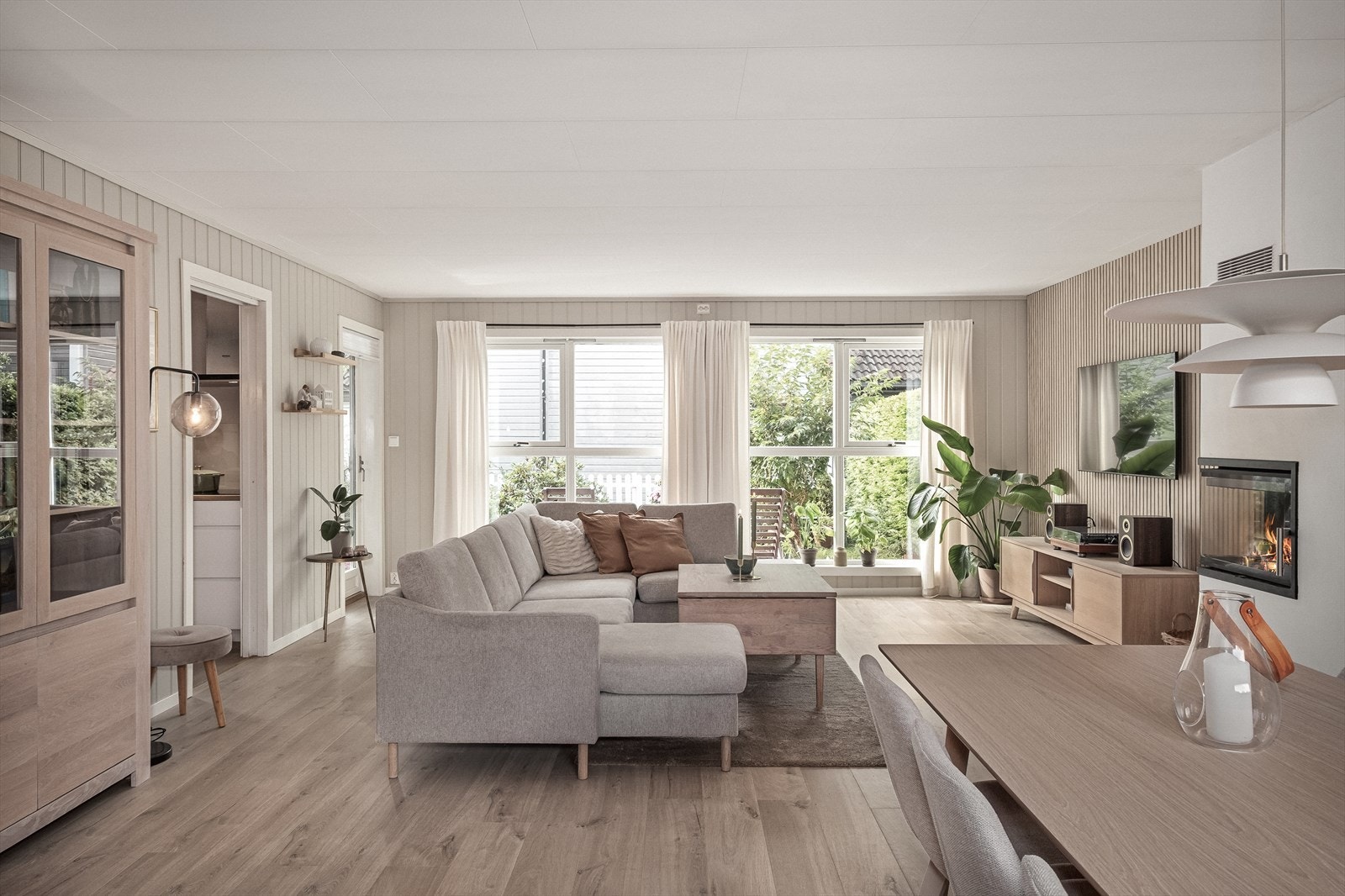 Store vindusflater mot solrik og fin hage Galleribilde