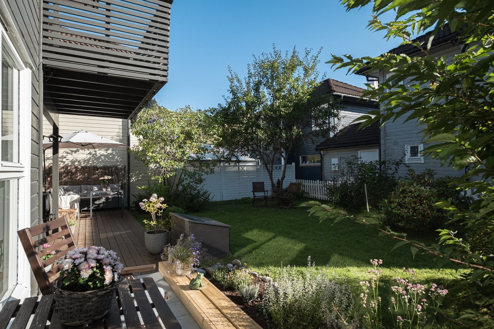 Hagen er pent beplantet med bed og prydbusker Galleribilde