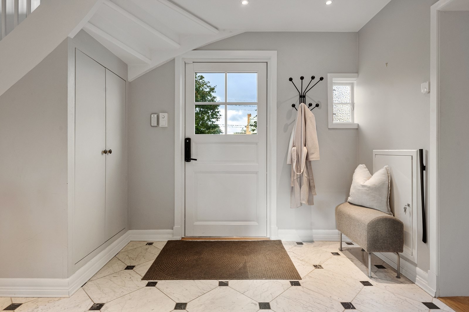 Rett innenfor døren møter du en stor hall, belagt med elegante marmorfliser fra Skogr og vannbåren varme som gir komfort og eksklusivitet Galleribilde