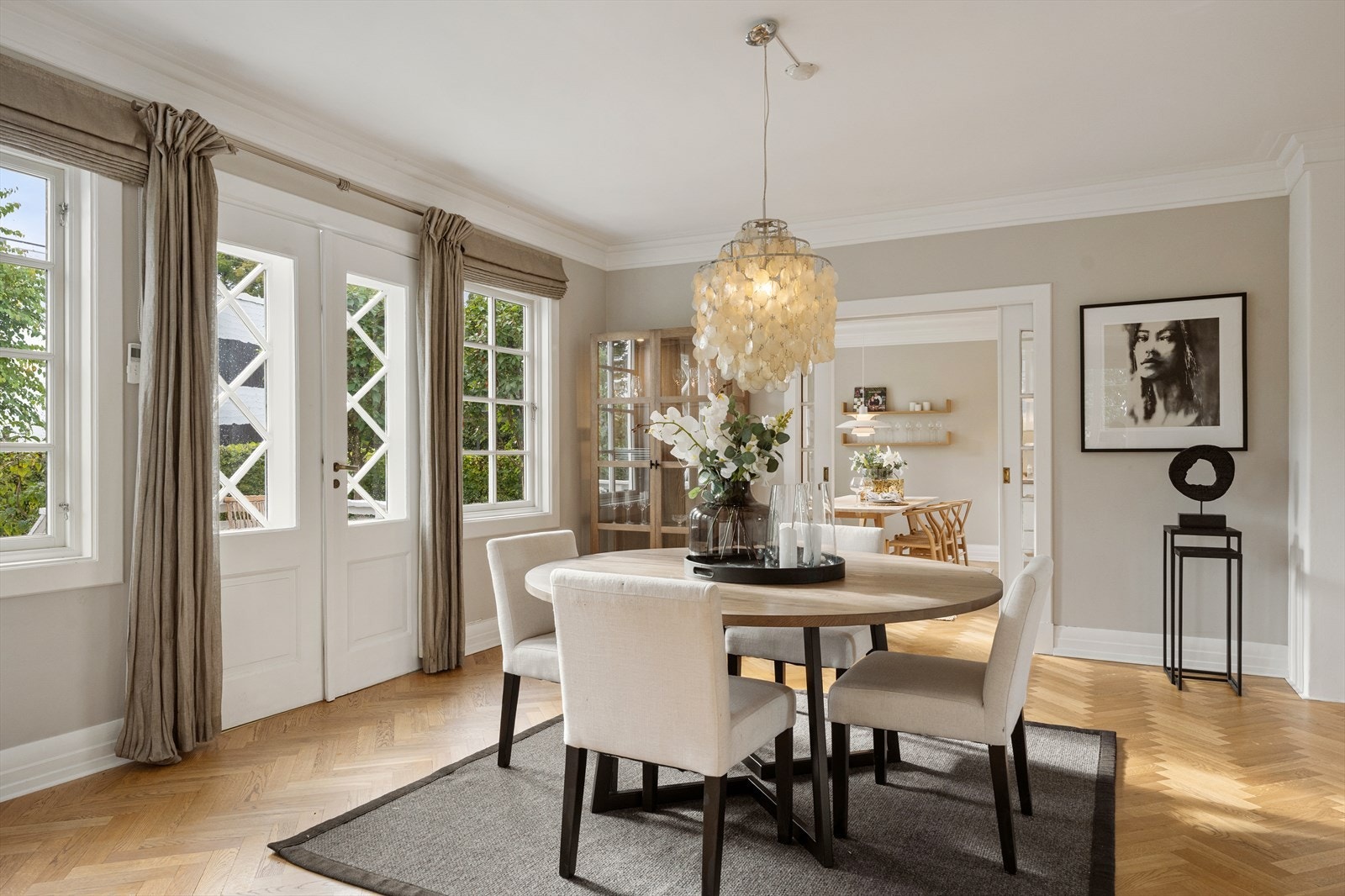 Elegant overgang fra kjøkken til spisestue gjennom originale skyvedører, samt gulv belagt med lekker fiskebensparkett. Galleribilde