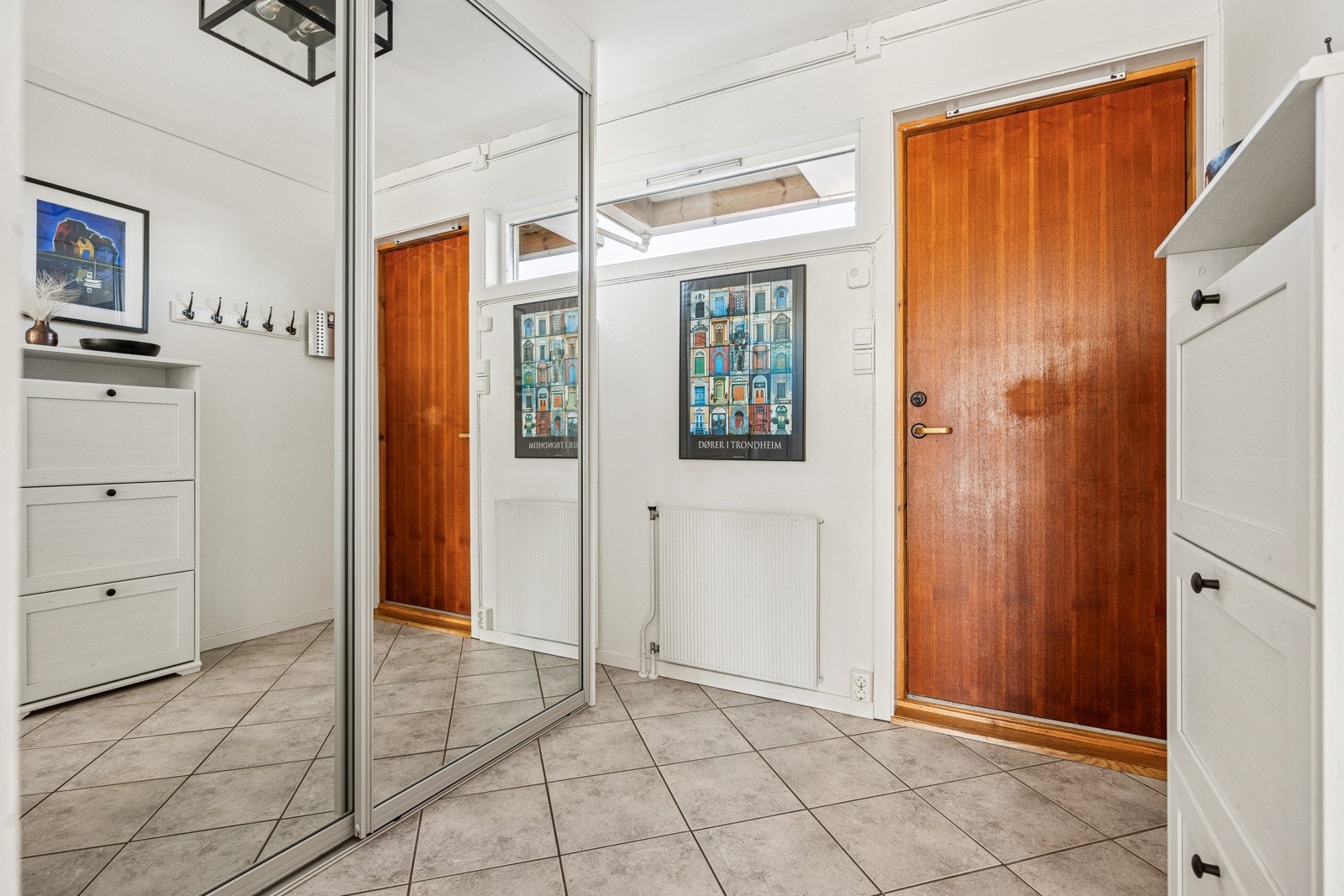 Velkommen inn! Entréen gir god plass til oppbevaring av hele familiens sko og tøy i en romslig skyvedørsgarderobe med speilfronter. Galleribilde