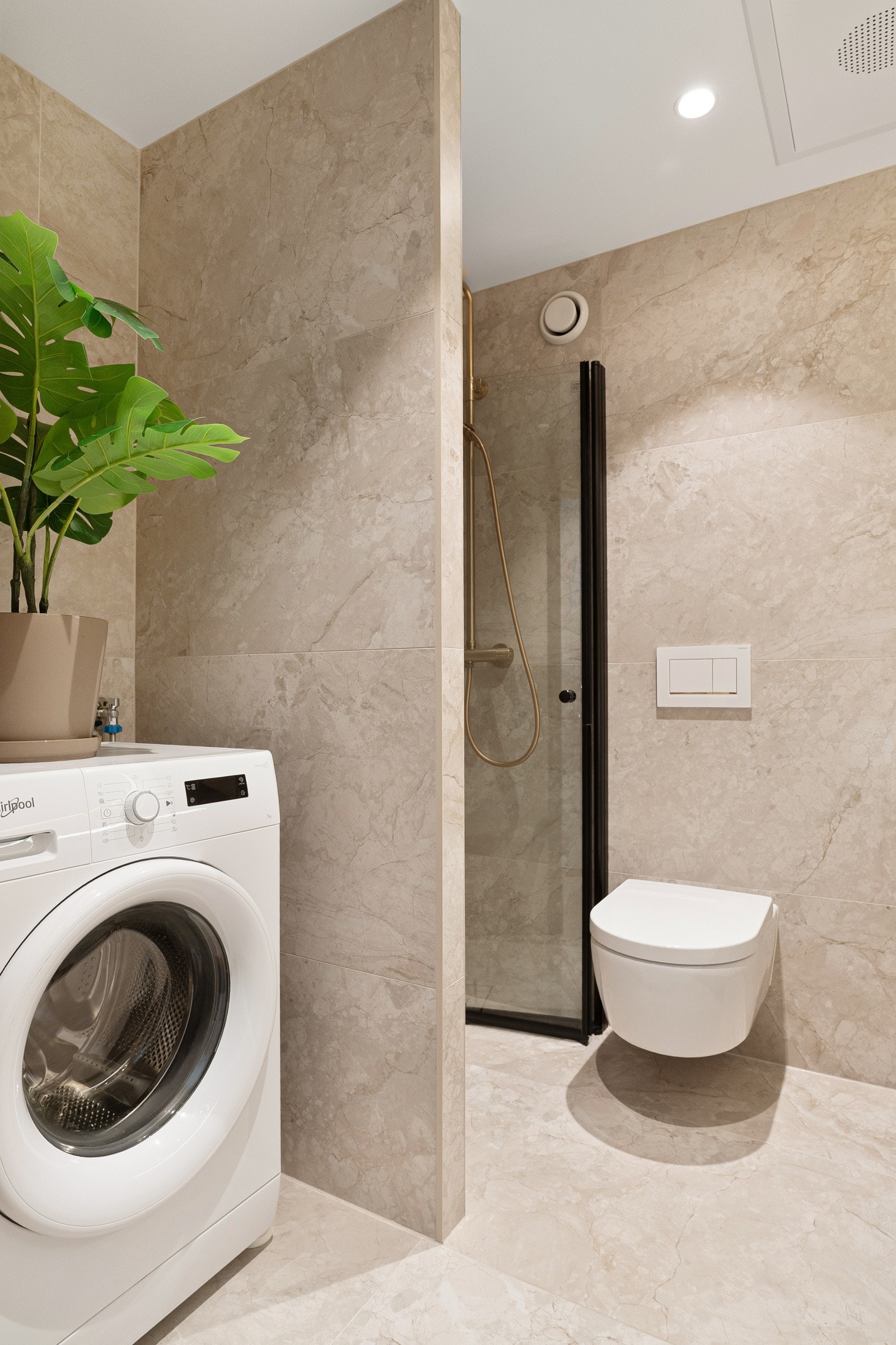 Baderomsinnredningen byr på servantskap, rundt speil med integrert belysning, dusjhjørne med foldedør og toalett. Galleribilde