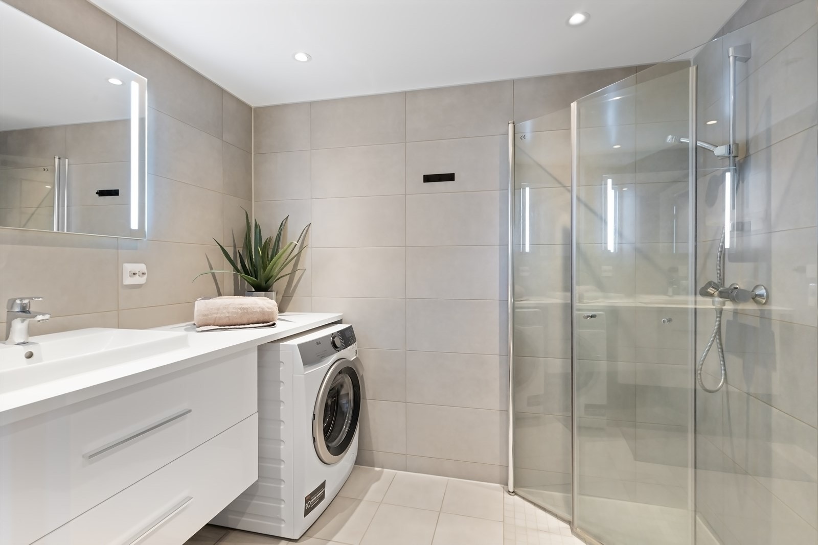 Innredet med hjørnedusj, servant med skuffer, ledspeil og opplegg for vaskemaskin. Vannbåren gulvvarme. Galleribilde