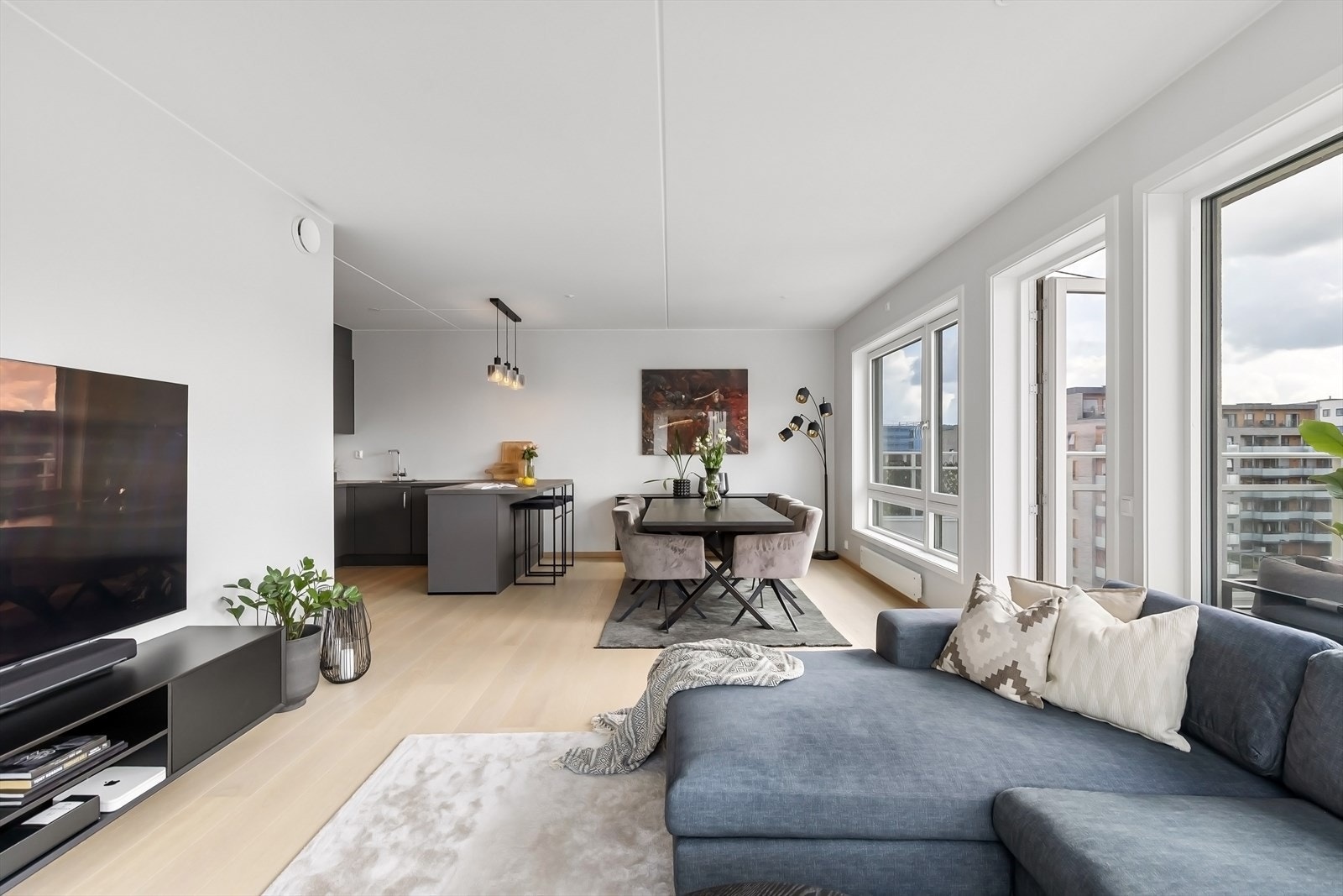 Vinduer langs hele langsiden av rommet. Lysmalte overflater og enstavs parkett på gulv. Galleribilde