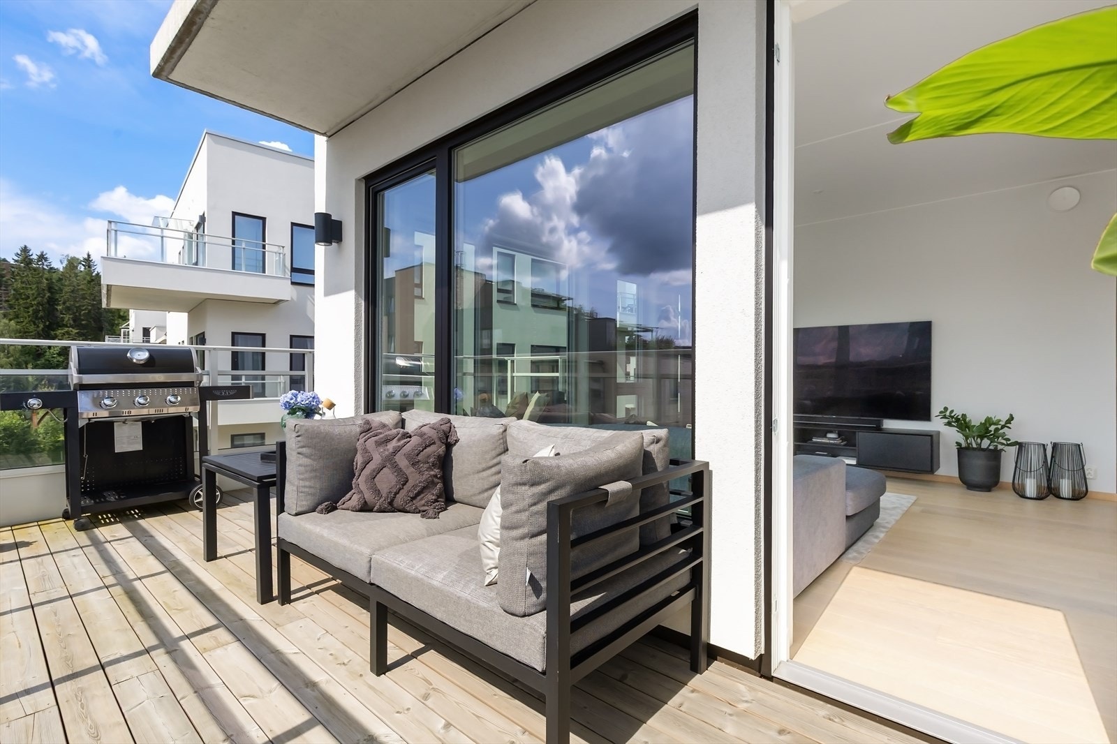 Balkongen er av betongkonstruksjon, terrassebord på bjelkelag og rekkverk med glass. Galleribilde