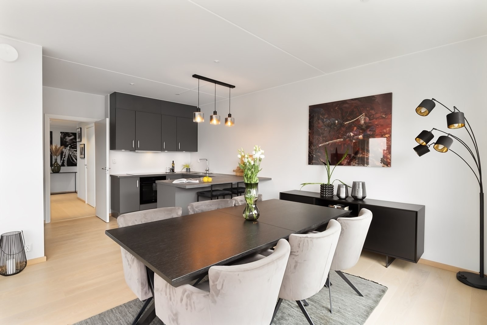 Pent kjøkken i åpen løsning mot spisestue og stue, samtidig tilbaketrukket fra sofagruppe. Galleribilde