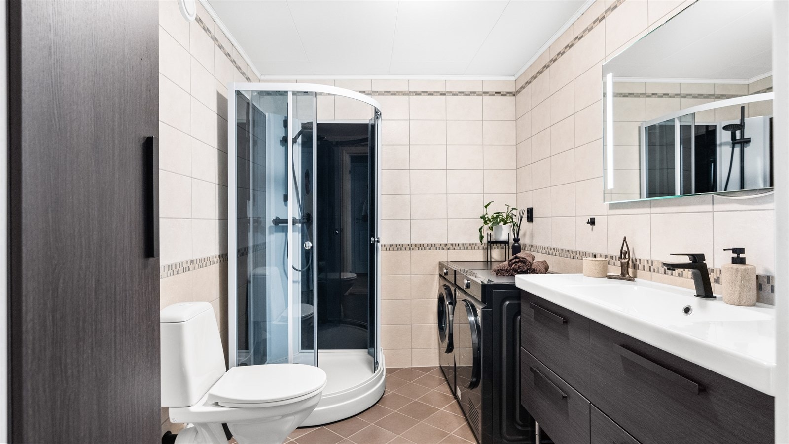 Innbydende baderom med flislagte overflater med behagelige gulvvarme. Galleribilde