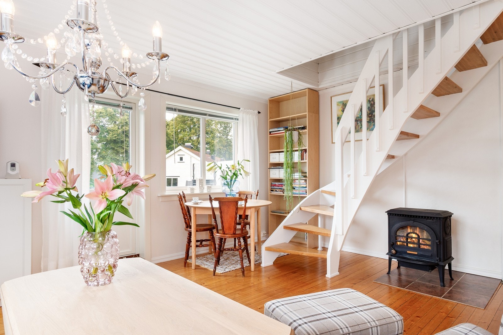 Stuen har heltre furugulv, lyse overflater og en koselig peis som skaper en lun atmosfære. Galleribilde