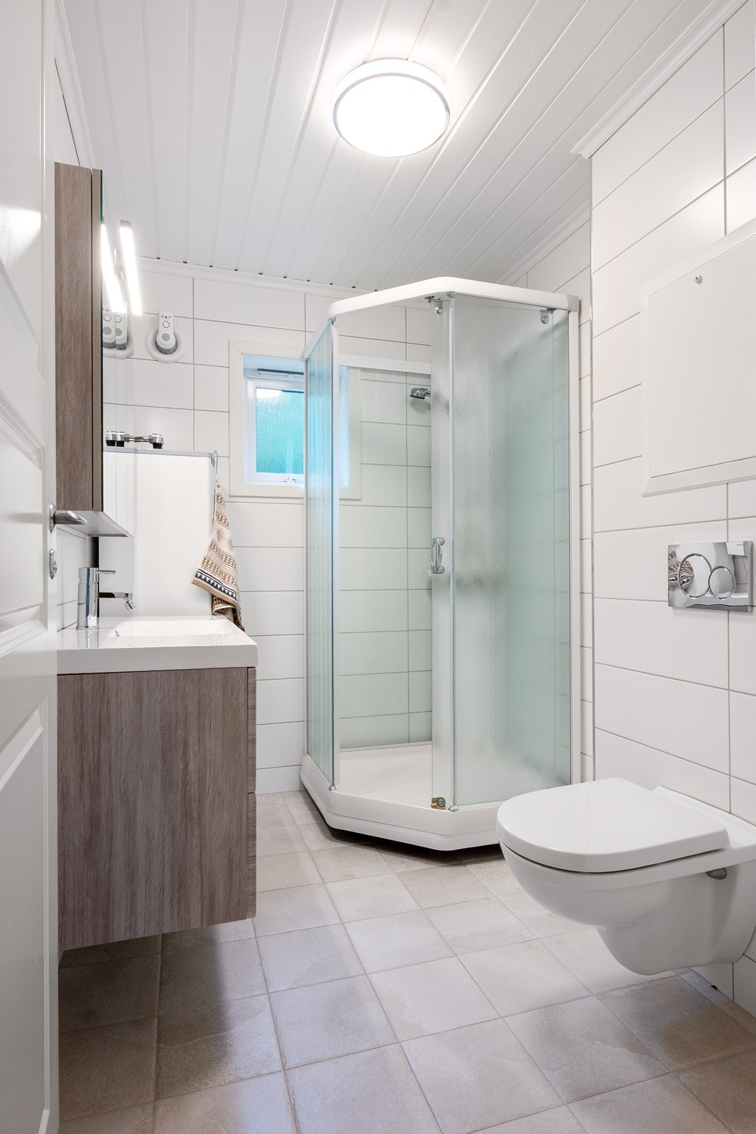 Innredningen består av servant med skuffer, overskap, dusjkabinett og vegghengt toalett. Galleribilde