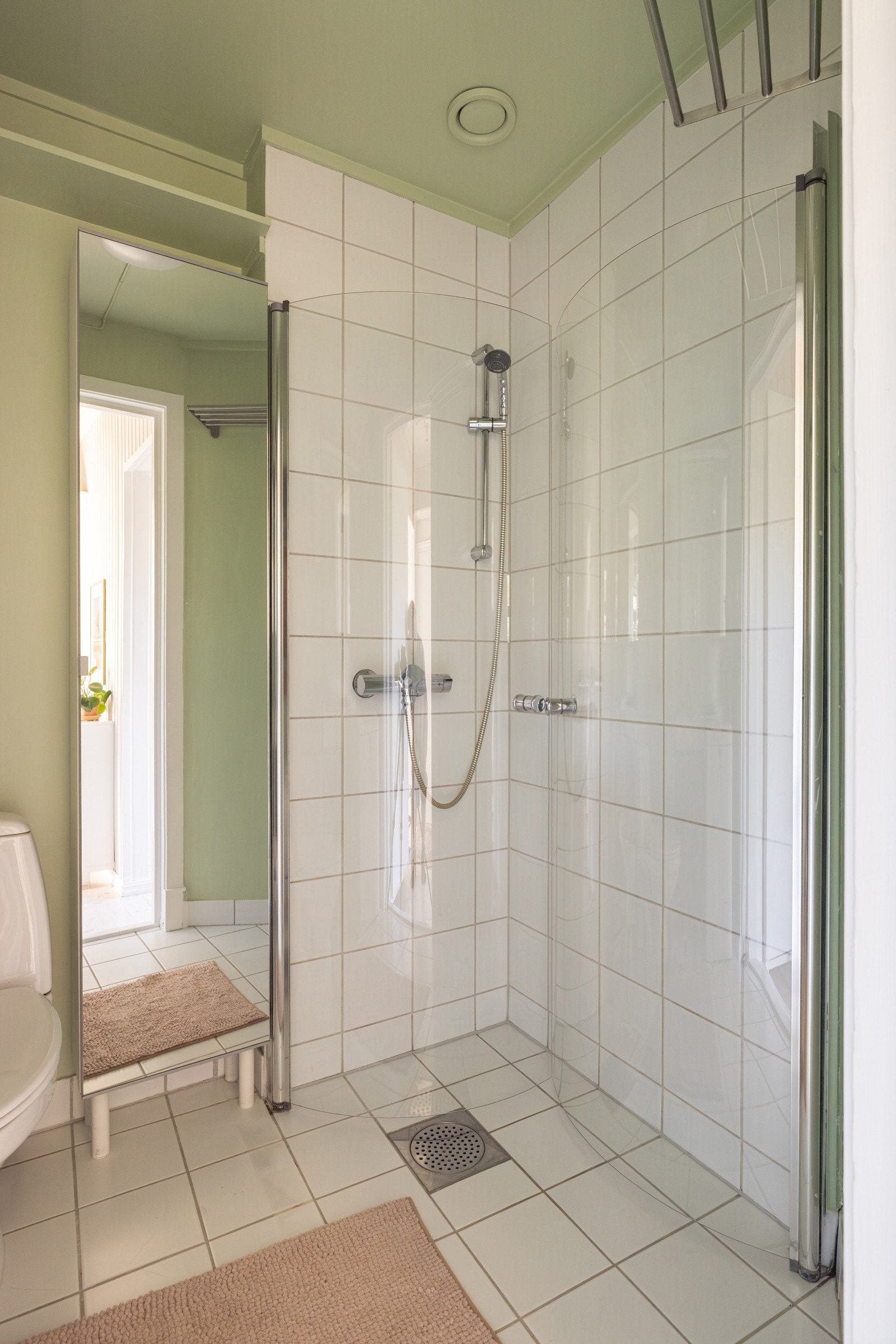 Baderommet er også utstyrt med dusjhjørne med innfellbare glassdører, høyskap med speilfront og gulvstående toalett. I hjørnet er det plass og opplegg for vaskemaskin. Galleribilde