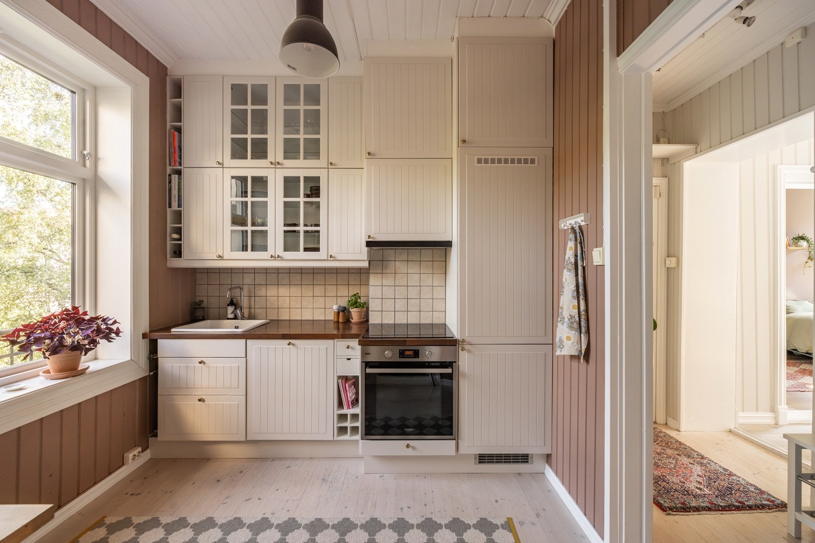 Rommet er godt utnyttet og det er rikelig med skapplass i takhøy kjøkkeninnedning og det er pen laminat benkeplate med praktiske veggfliser på vegg. Galleribilde