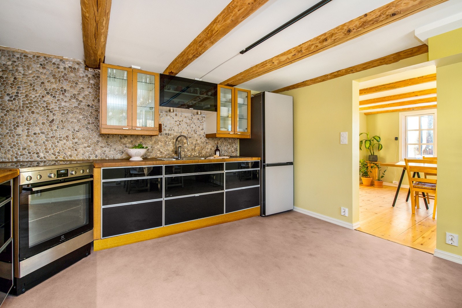 Ikea-innredningen fra rundt 2010 har vitrineskap, sorte, glatte fronter og dobbel oppvaskkum nedfelt i benkeplaten. Galleribilde