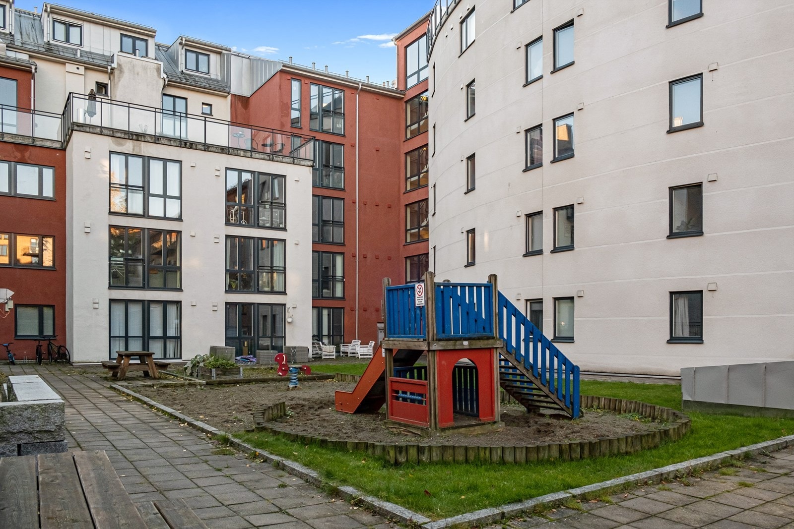 Hyggelig bakgård som er opparbeidet med sittegrupper, lekestativ og sandkasser. Galleribilde