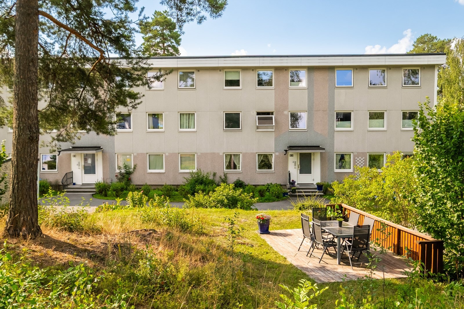 Utenfor inngangen finner du et hyggelig fellesområde med platting, spisebord og stoler Galleribilde