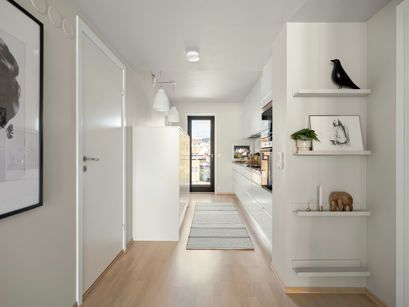 Fra entréen blir man ført videre til hjertet av boligen med kjøkkenet på den ene siden og stuen på den andre. Det er heller ikke her spart på detaljene. Galleribilde