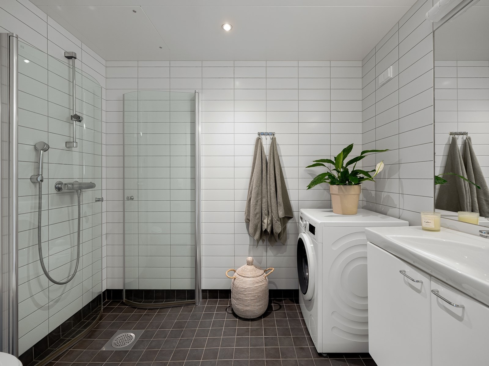 Badet er flislagt med downlights i himling, innredet med walk-in dusj m/ innfellbare glassdører som er superpraktisk når dusjen ikke er i bruk. Galleribilde