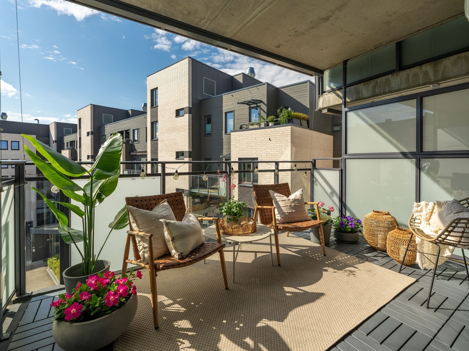 Balkongen er av god størrelse, og er delikat utført med delvis frostet rekkverkglass og flotte terrassefliser i tre som gir balkongen et stilfullt og hjemmekoselig uttrykk. Galleribilde