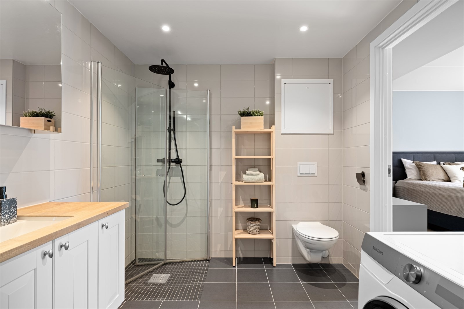 Vegghengt wc, baderomsinnredning og opplegg for vaskemaskin. Galleribilde