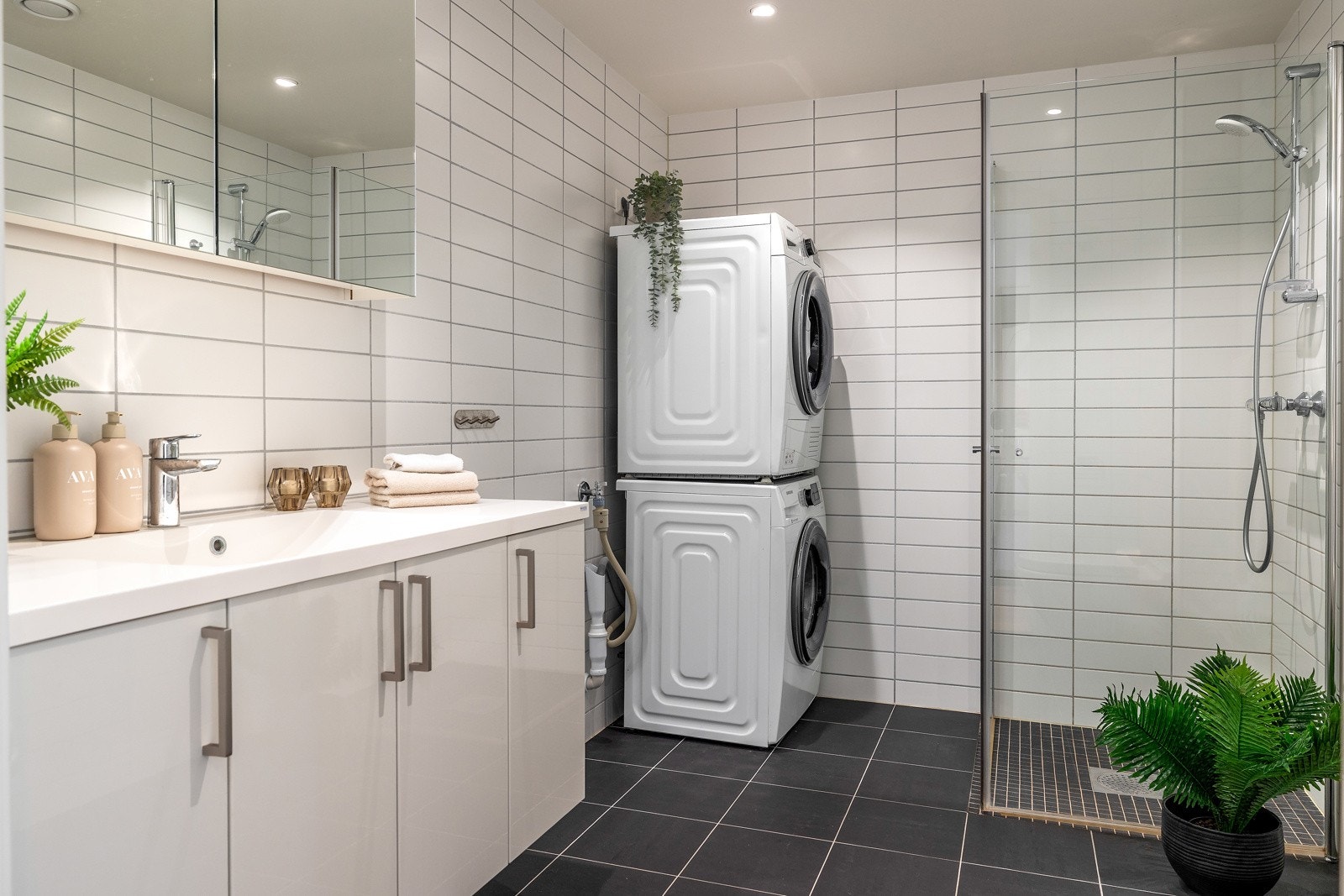 Leilighetens bad er flislagt og har opplegg for vaskemaskin og tørketrommel Galleribilde