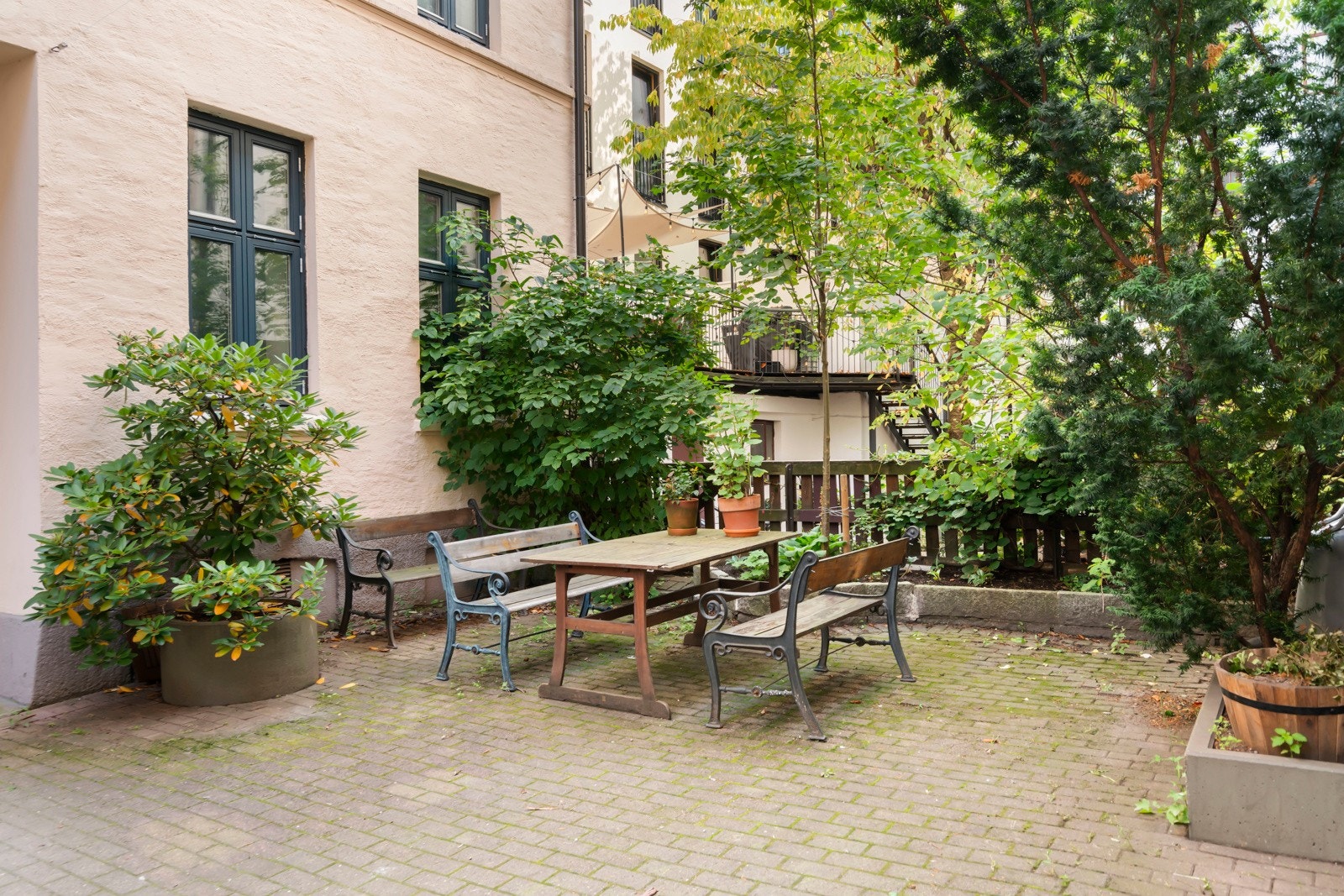 Bakgården er pent opparbeidet med sittegrupper, beplantning og oppstillingsplass for sykler Galleribilde