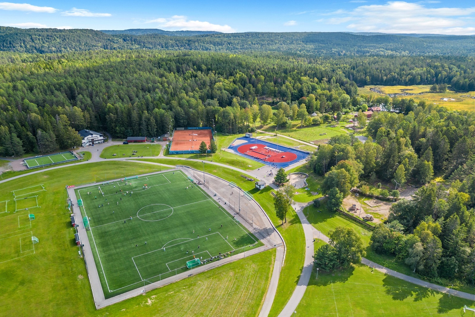 Haraløkka Idrettsanlegg ligger rett ved boligen med tennisbane, løpebane og kunstgressbane Galleribilde