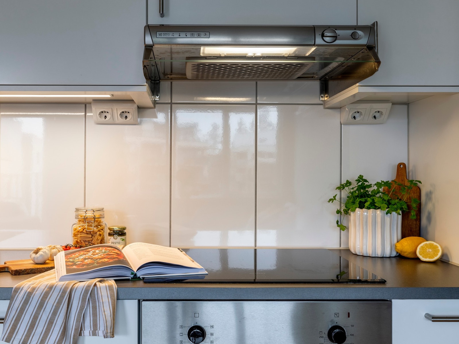 Det er praktisk belysning over benken, og det er flisfelt mellom overskap og kjøkkenbenk som gir et stilfullt preg. Galleribilde