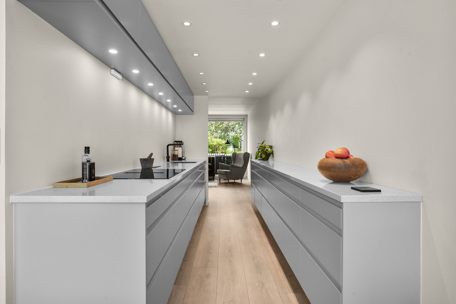 Lekkert kjøkken med downlights i både tak og under overskap. Bildet er tatt fra spisestuen mot stuedelen Galleribilde