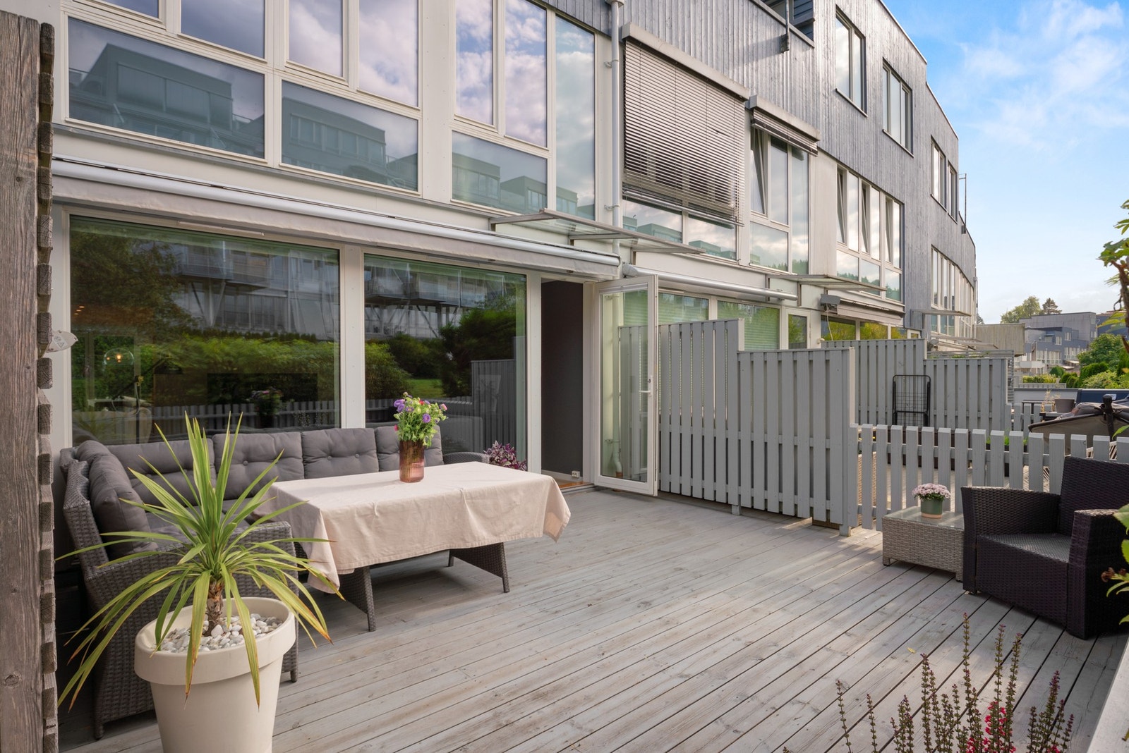 Terrassen vender mot rolig parkområdet og har glasstak over dørene gir beskyttelse mot vær og vind. Galleribilde