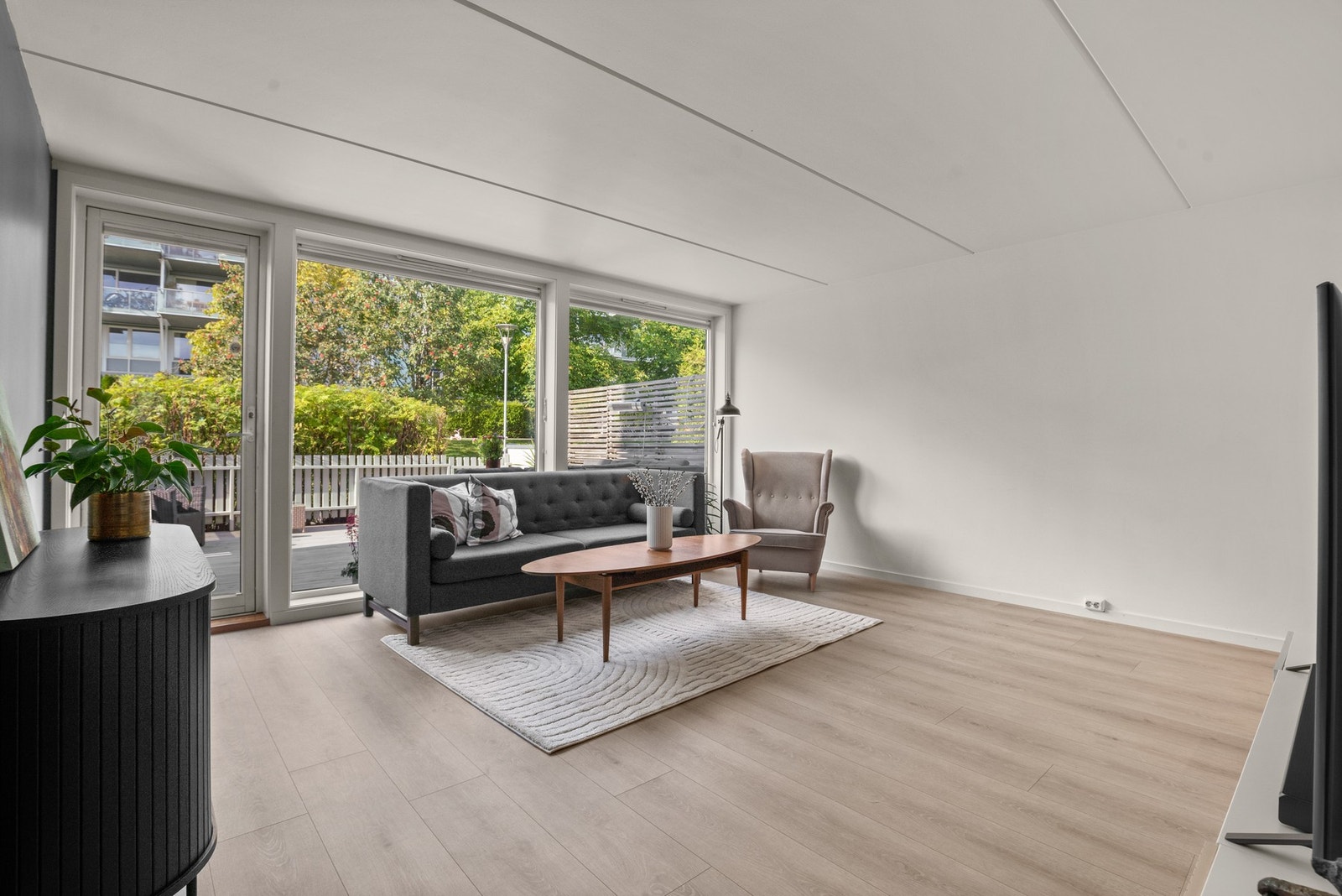 Lys og vennlig stue med utgang til stor terrasse. Terrassen vender inn mot det vakre, bilfrie parkområdet til sameiet. Her kommer solen tidlig ettermiddag og blir borte først ved 20-tiden (sommertid) Galleribilde