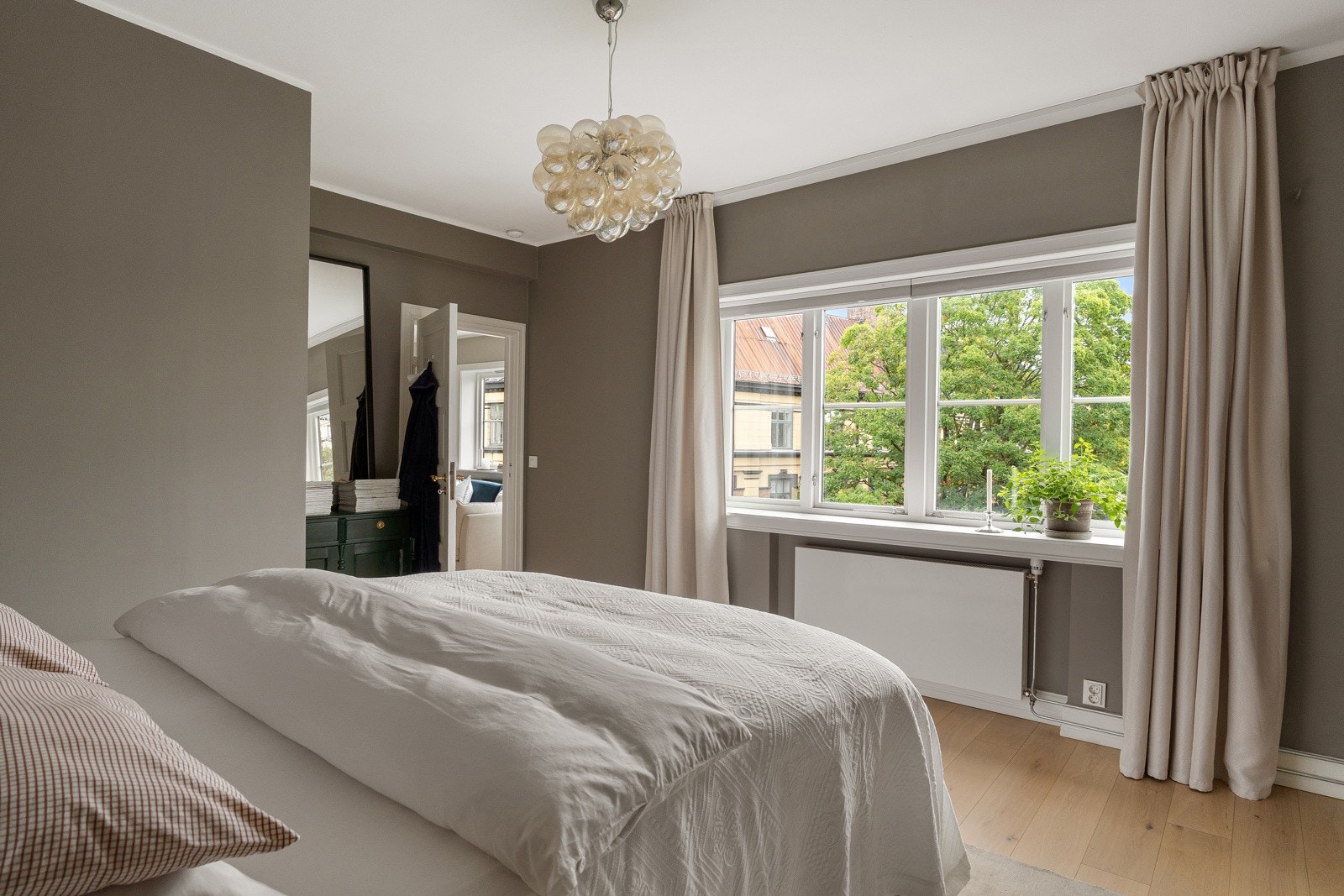 Hovedsoverommet er lyst og luftig med god plass til dobbeltseng og nattbord - grønt utsyn i rolig enveiskjørt gate. Galleribilde