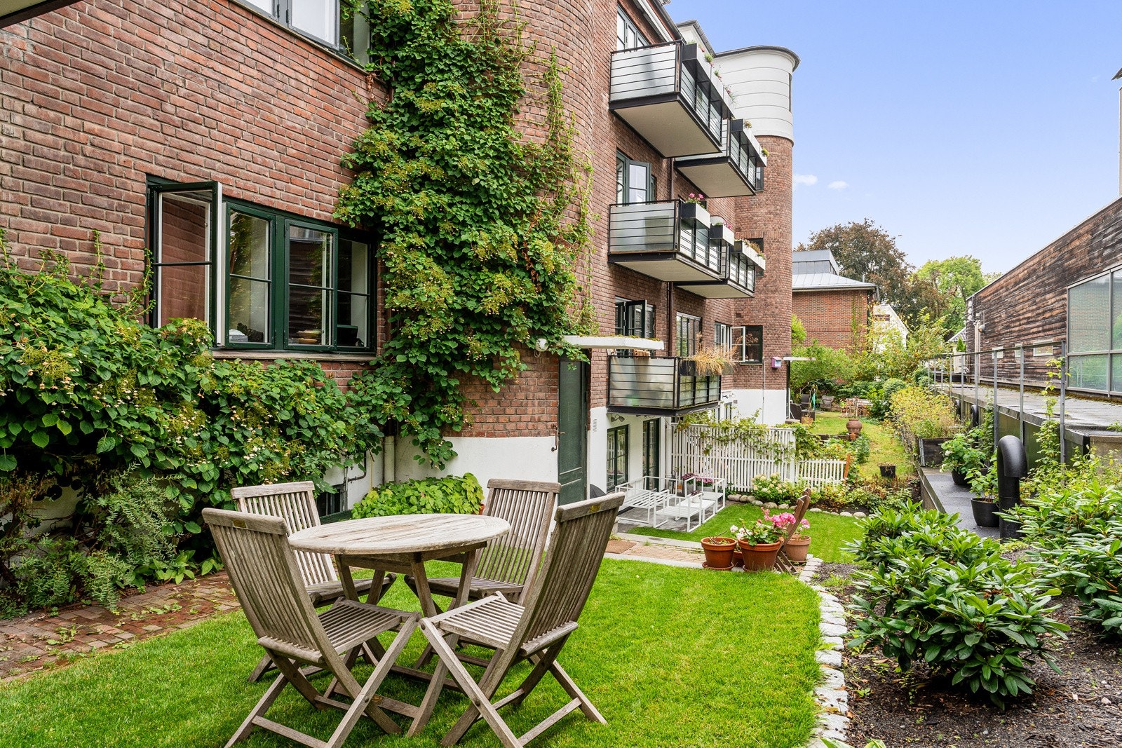 Aksjelaget byr på frodige fellesarealer med sittegrupper i idylliske omgivelser. Galleribilde