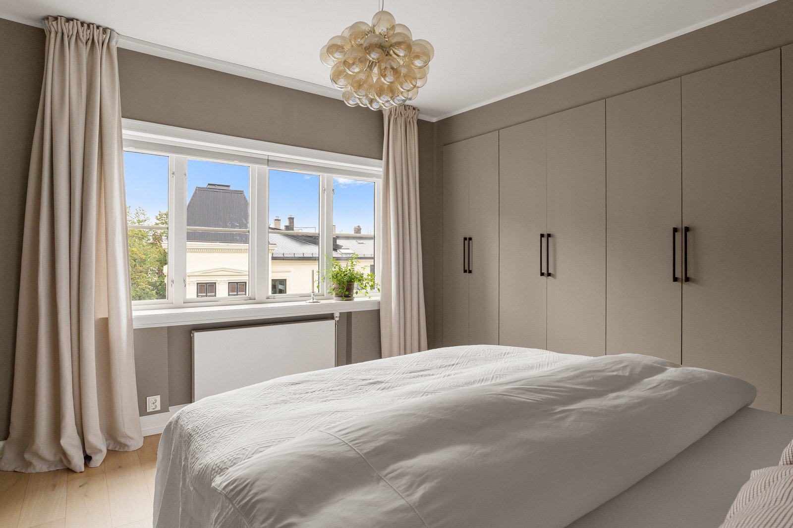 Plassbygd garderobeskap langs hele veggen som gir rikelig med oppbevaringsmuligheter. Galleribilde