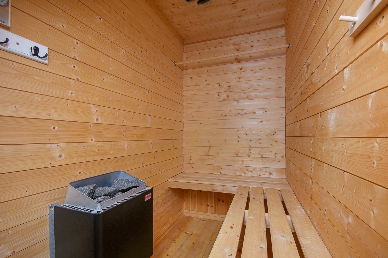 Badstuen er innredet med plassbygde benker og med panel på vegger. Kast på vannet og nyt en deilig og avslappende stund her inne etter en lang dag i fjellheimen. Galleribilde