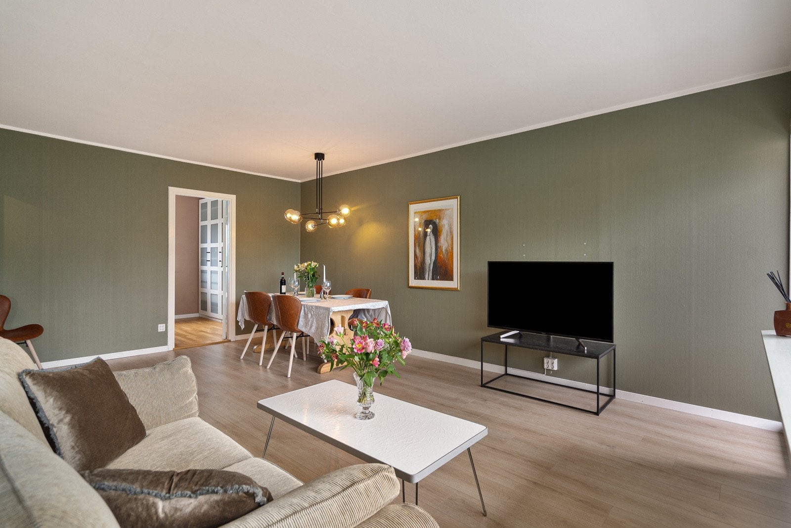 Overflatene er lyse og gjennomgående, med laminat på gulv og malte plater på vegger og tak. Galleribilde