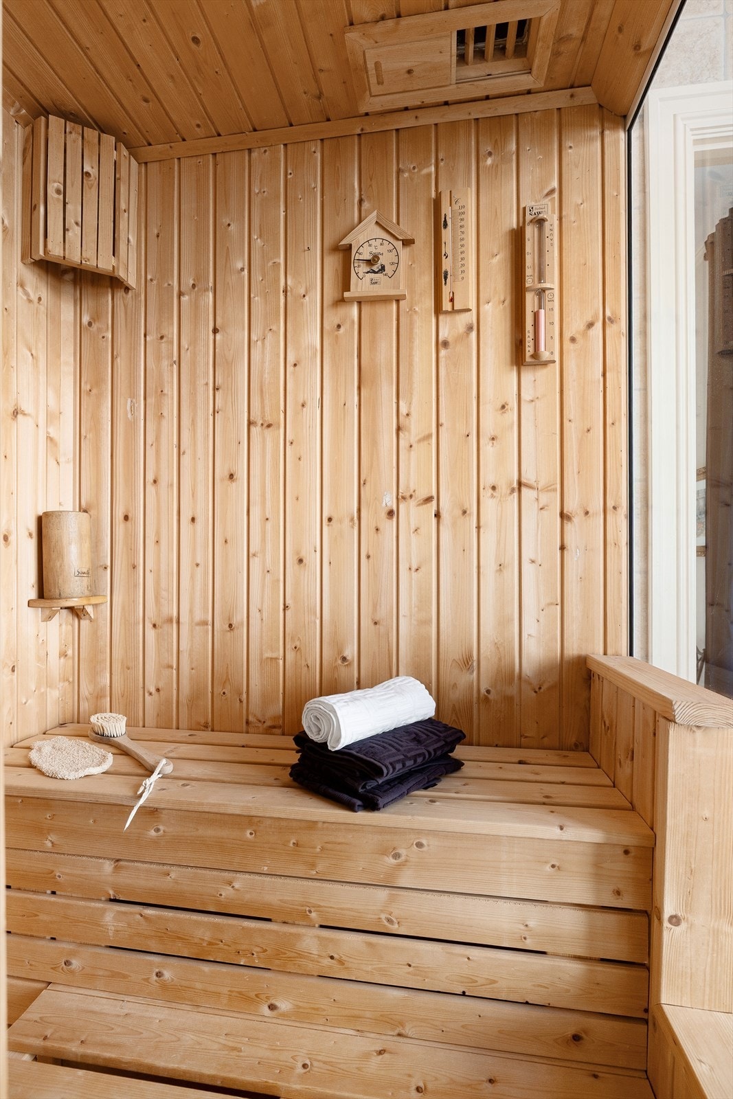 Badstue med vegger og himling med panel, badstueovn på vegg og naturlig avtrekksventil i himling. Galleribilde