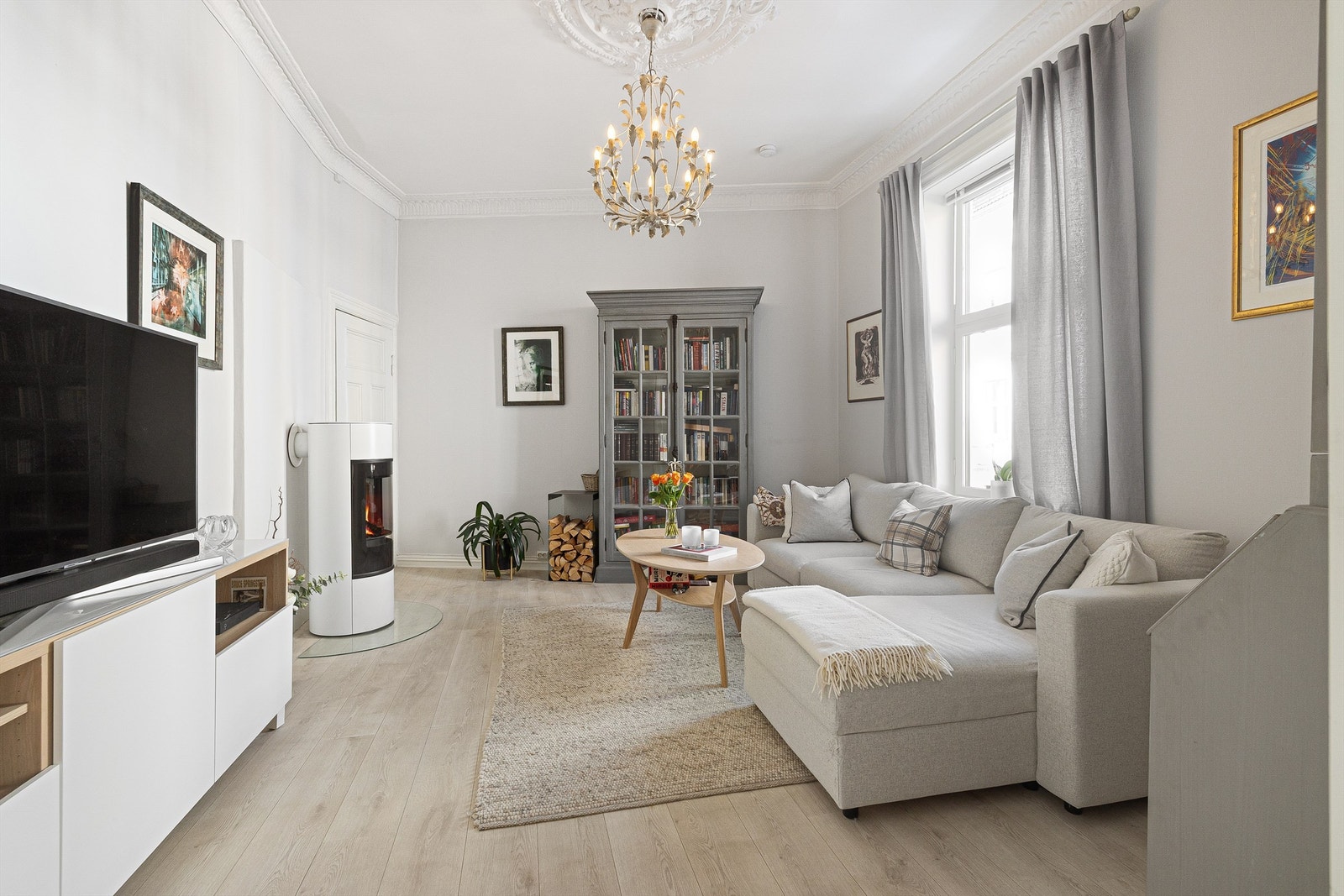 En innbydende stue med en-stavs laminat og peisovn fra 2022. Galleribilde