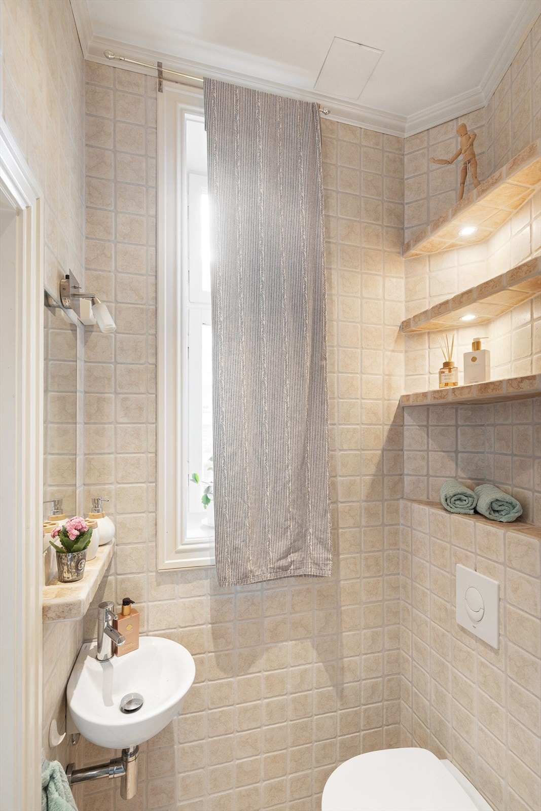 Vegghengt servant med ettgreps armatur og innfelt speil og belysning samt stikkontakt på vegg over servant. Galleribilde