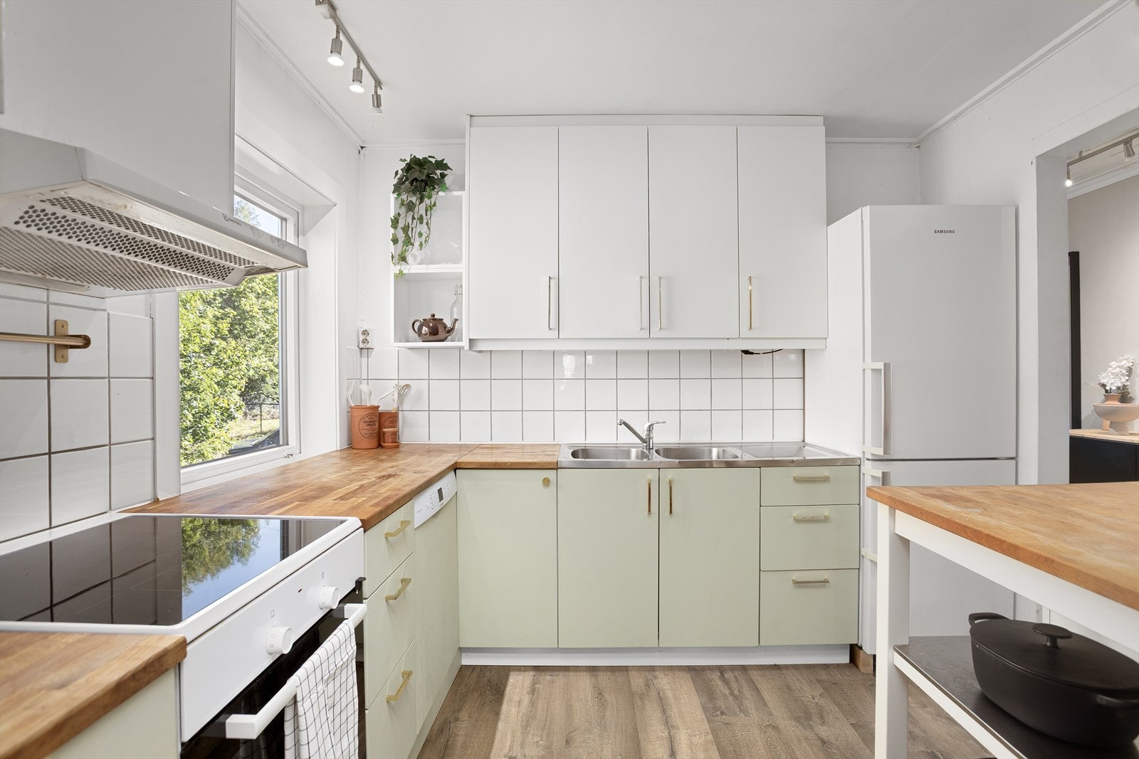 Innredningen har glatte fronter, heltre benkeplate og det er fliser mellom benkeplate og overskap. Galleribilde