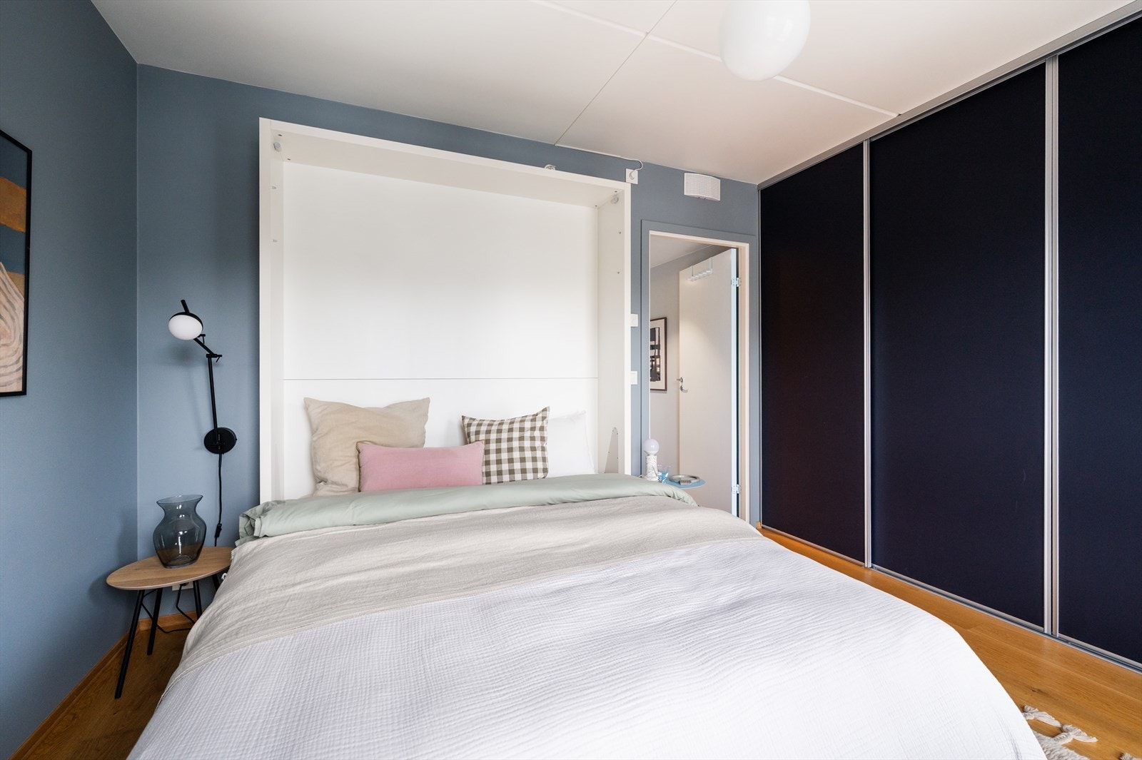 Praktisk skyvedørsgarderobe fra gulv til himling gir rikelig med oppbevaringsplass. Galleribilde