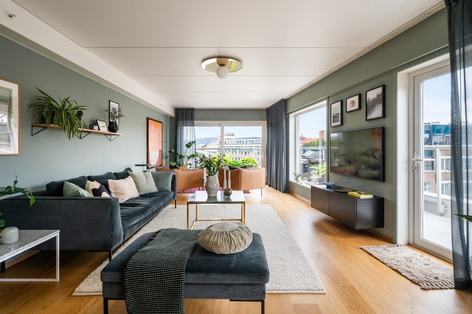 Lys og romslig stue med flere store vindusflater fra ulike vinkler som slipper inn rikelig med dagslys. Galleribilde