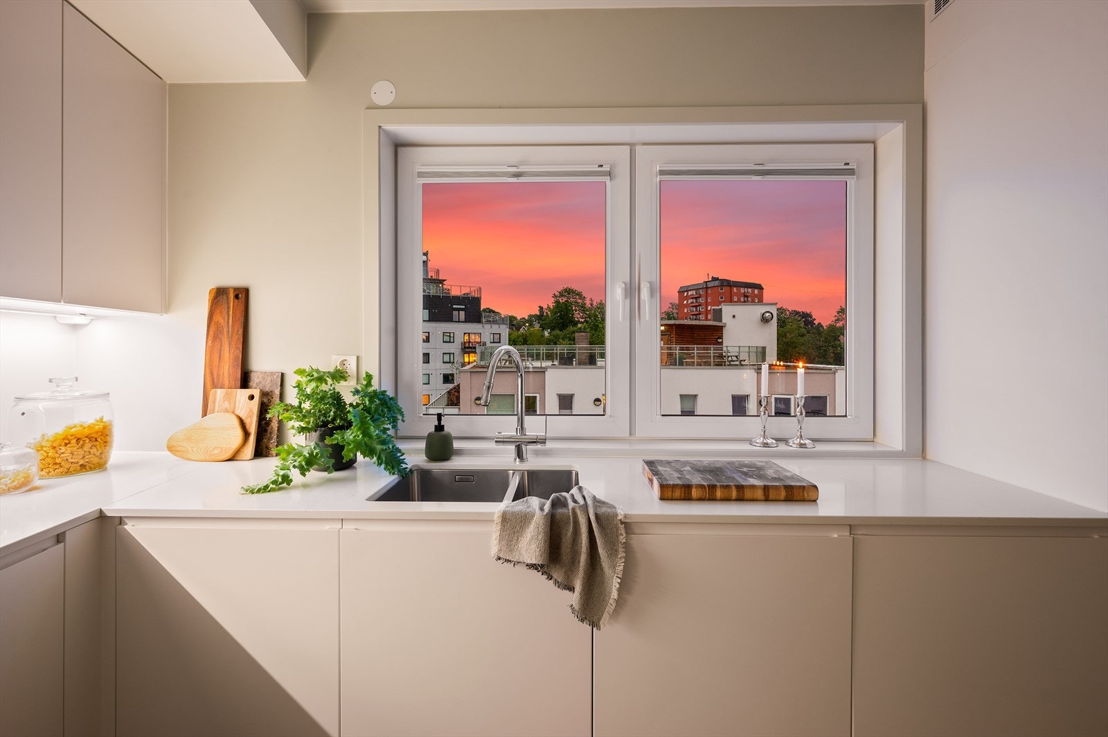 Stilrent og romslig kjøkken med glatte fronter og eksklusiv Silestone benkeplate med underlimt vaskekum. Galleribilde