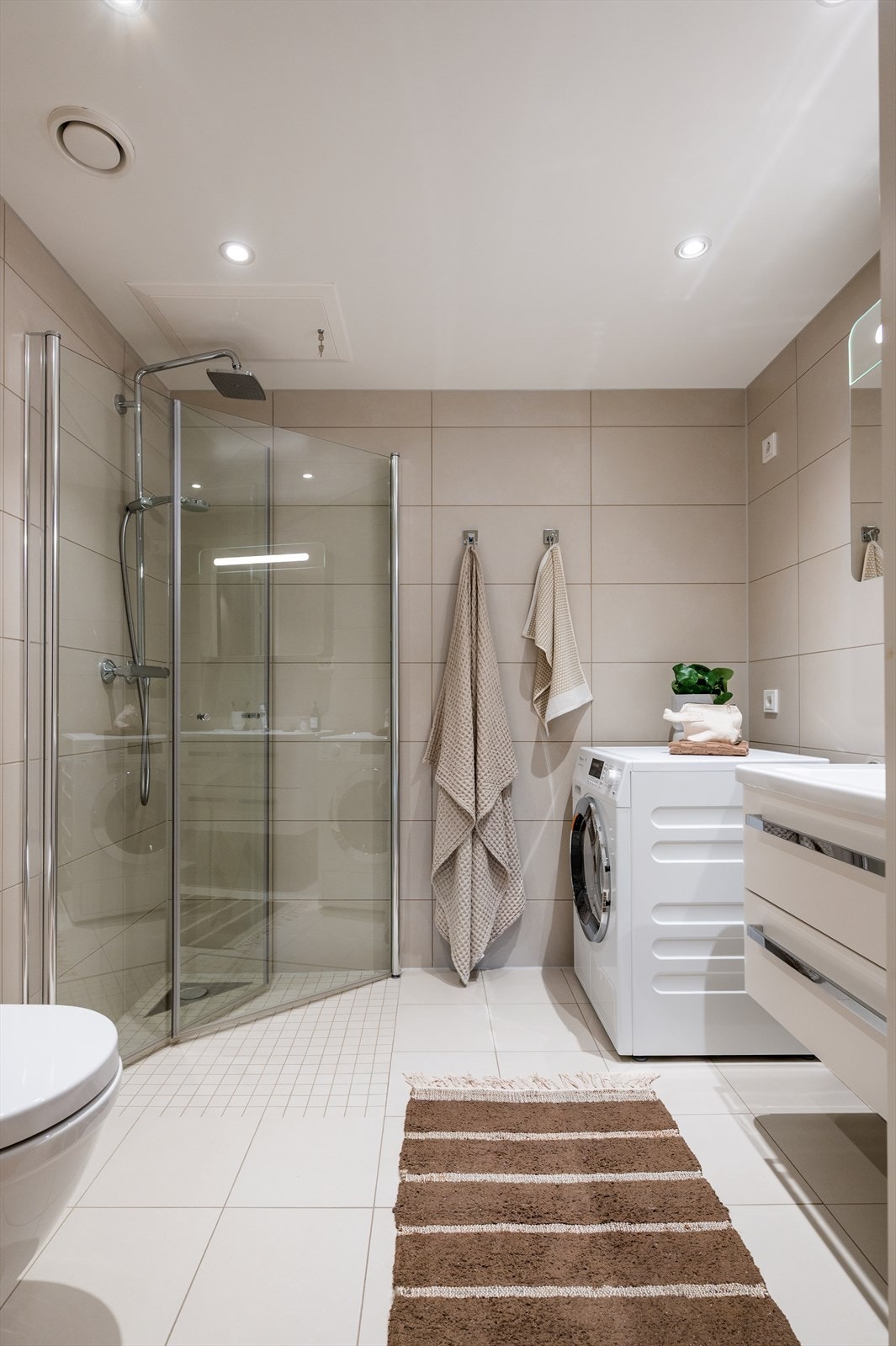 Boligens andre bad er også flislagt med elektrisk gulvvarme og innfelt downlights. Galleribilde