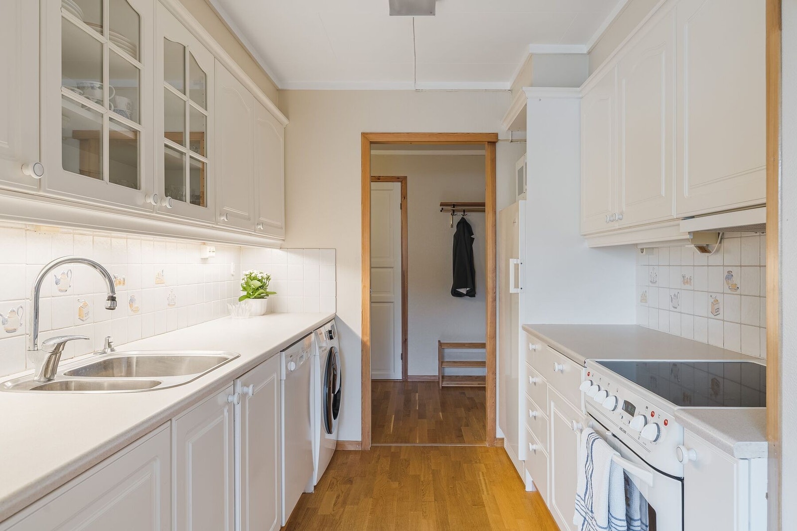 Klassisk hvitt kjøkken med mye skap- og benkeplass. Galleribilde