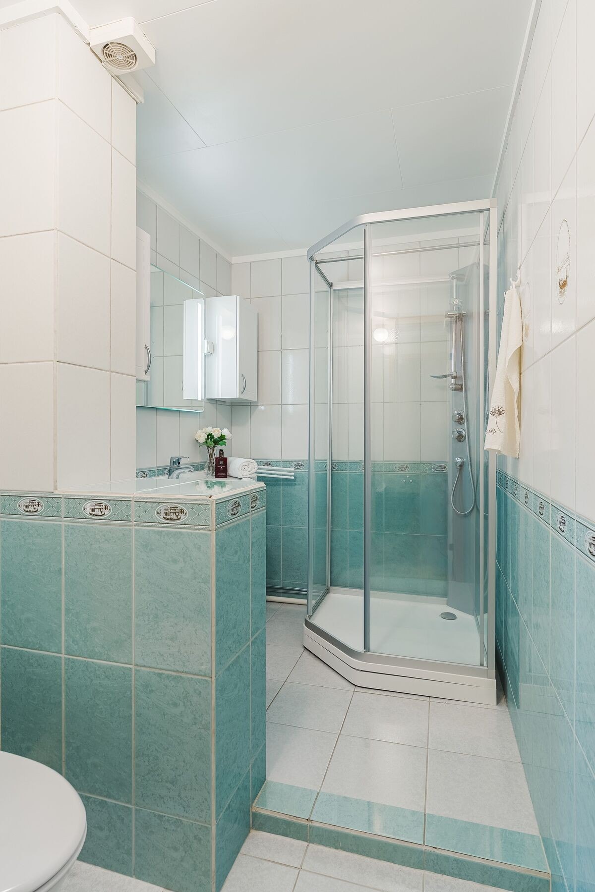 Badet er utstyrt med dusjkabinett, toalett og innredning med servant. Galleribilde