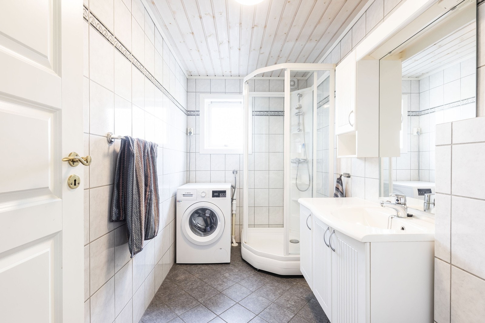 Badet er utstyrt med dusjkabinett, veggmontert wc, rørfordelingsskap, mekanisk avtrekk, servant, servantskap, opplegg for vaskemaskin og stoppekran. Galleribilde
