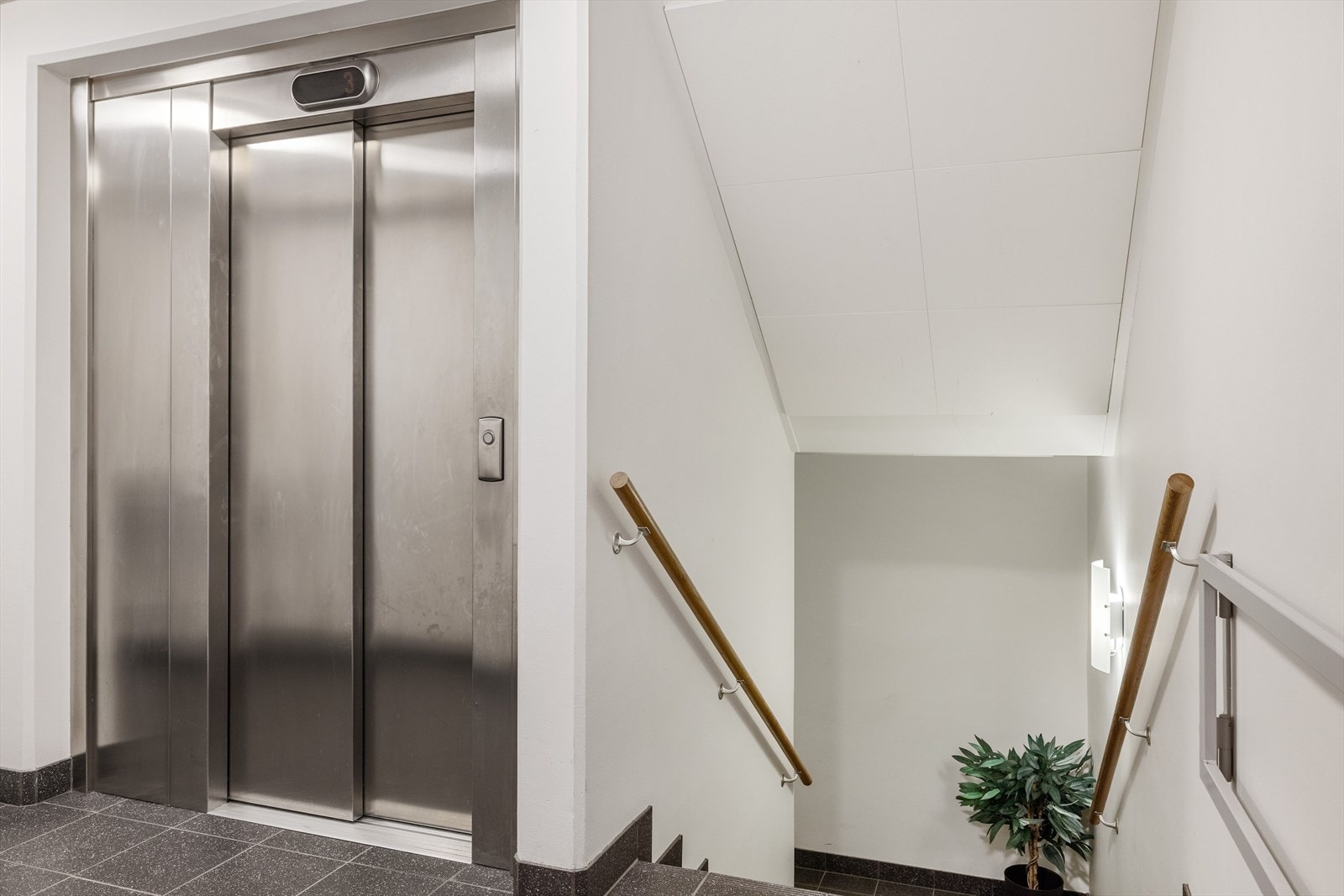 Felles trapperom med flislagt gulv og heis. Galleribilde