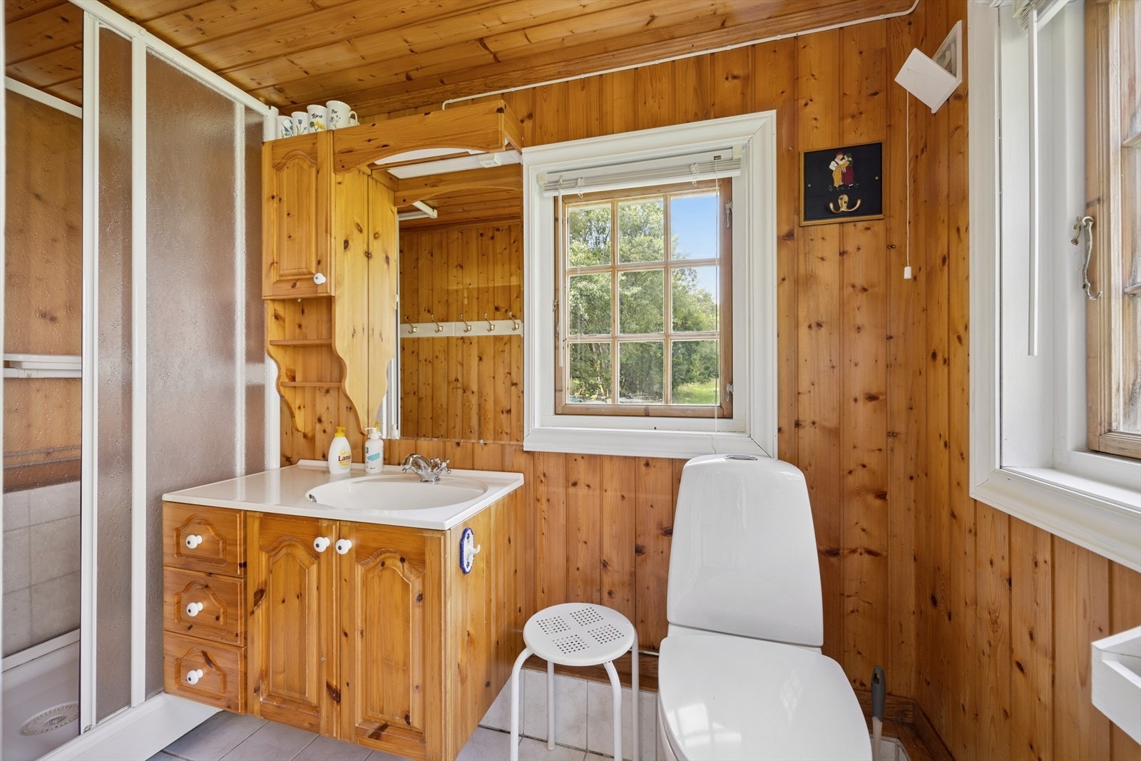 Badet er innredet med baderomsinnredning, toalett og dusjkabinett. Galleribilde