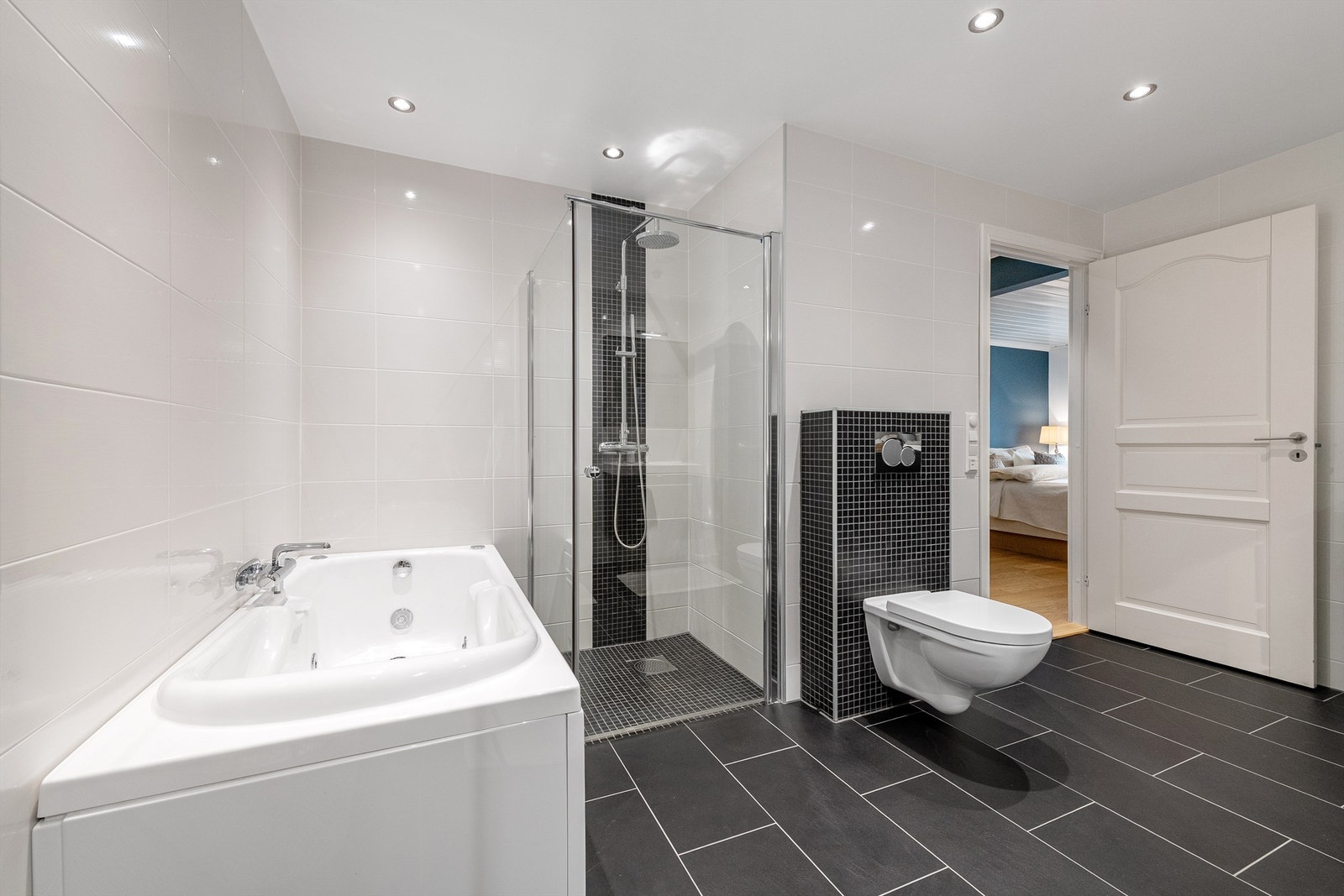 Boblebadekar, dusjhjørne med glassvegger og vegghengt dusjarmatur med hånddusj og regndusj. Vegghengt toalett Galleribilde