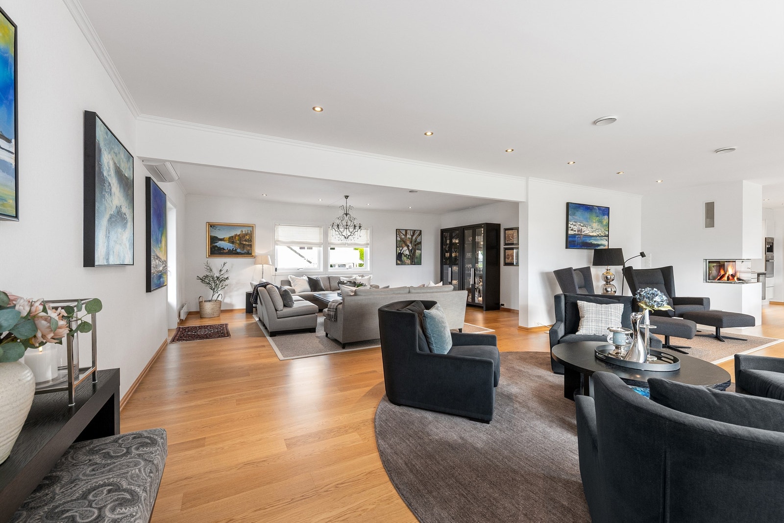 Stuen er delt inn i soner og har en moderne peis med glassinnsats Galleribilde