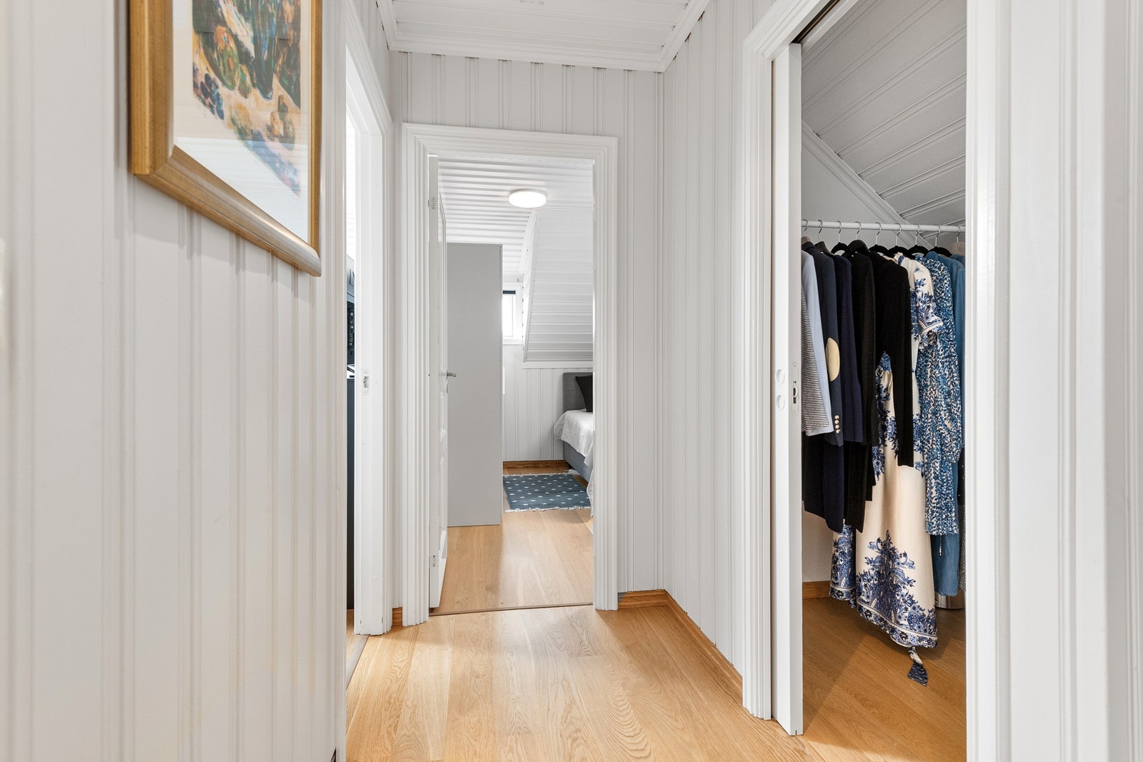 Gang i loftsetasjen med eikeparkett på gulv, malte panelte vegger og tak. Galleribilde